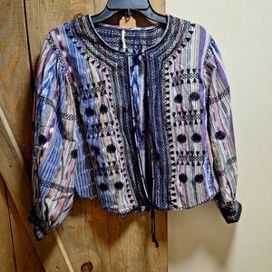 A Free People long sleeve blouse with string ties in the front in a size small.